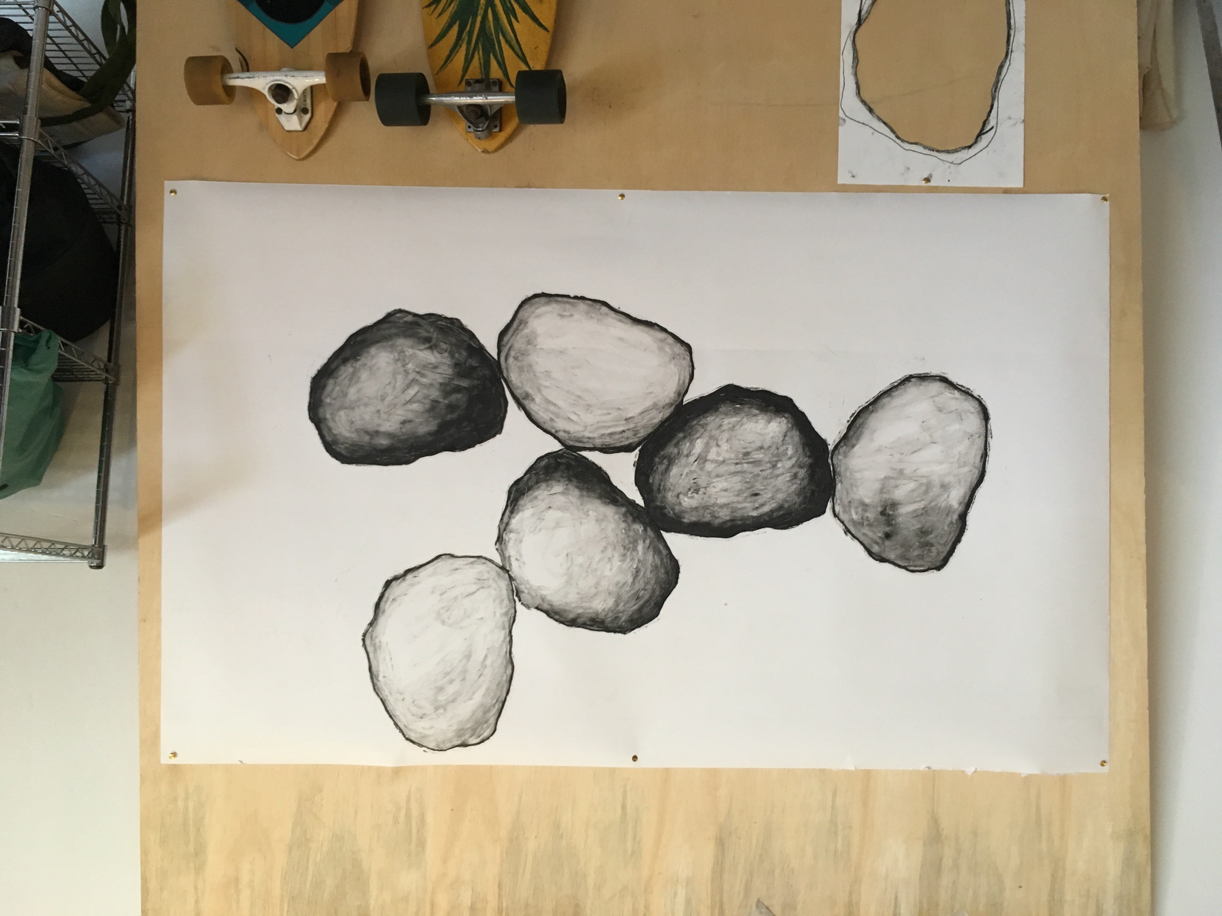 Desenho de formas arredondadas sobre papel fixado em painel.