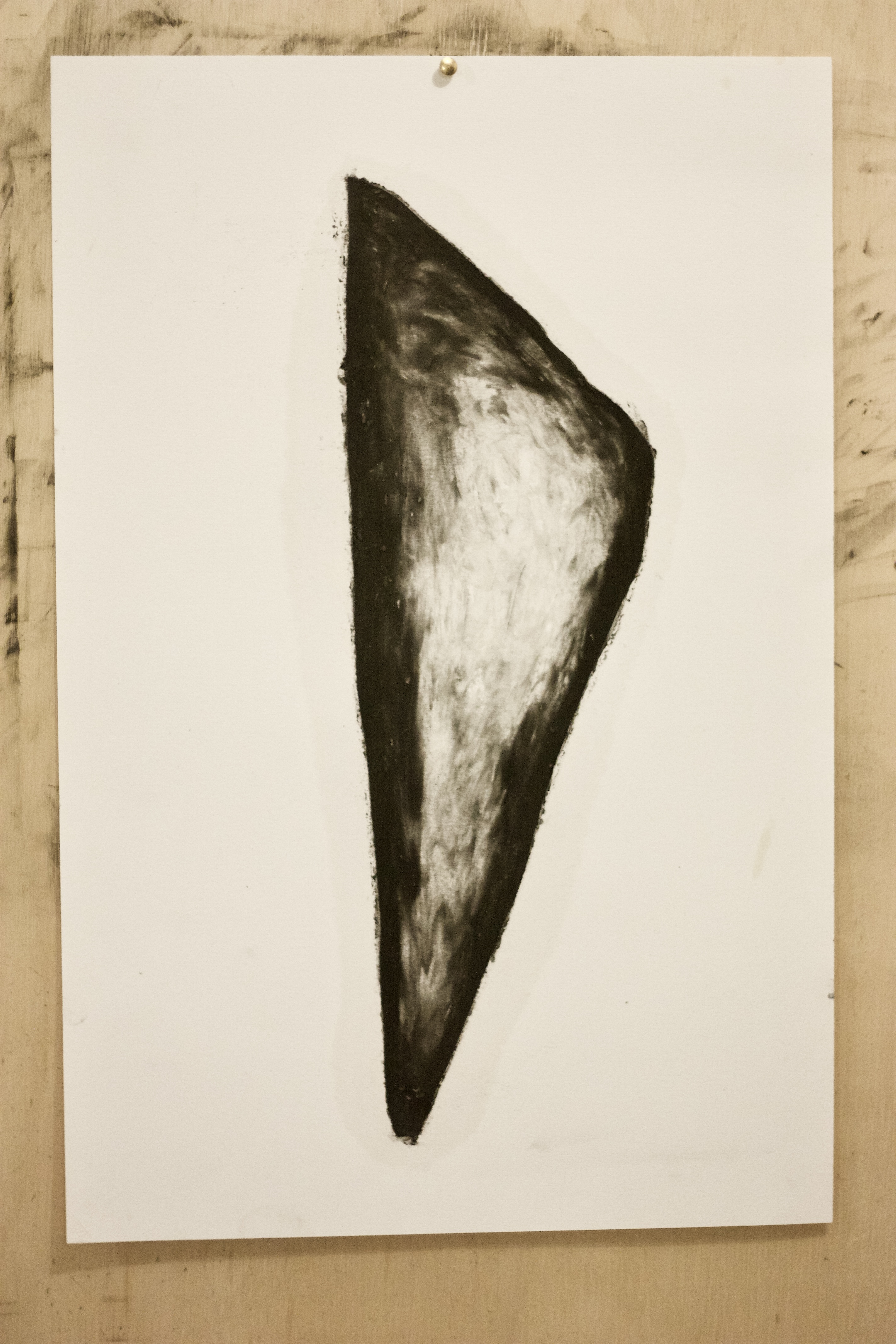 Forma vertical escura desenhada sobre papel claro.