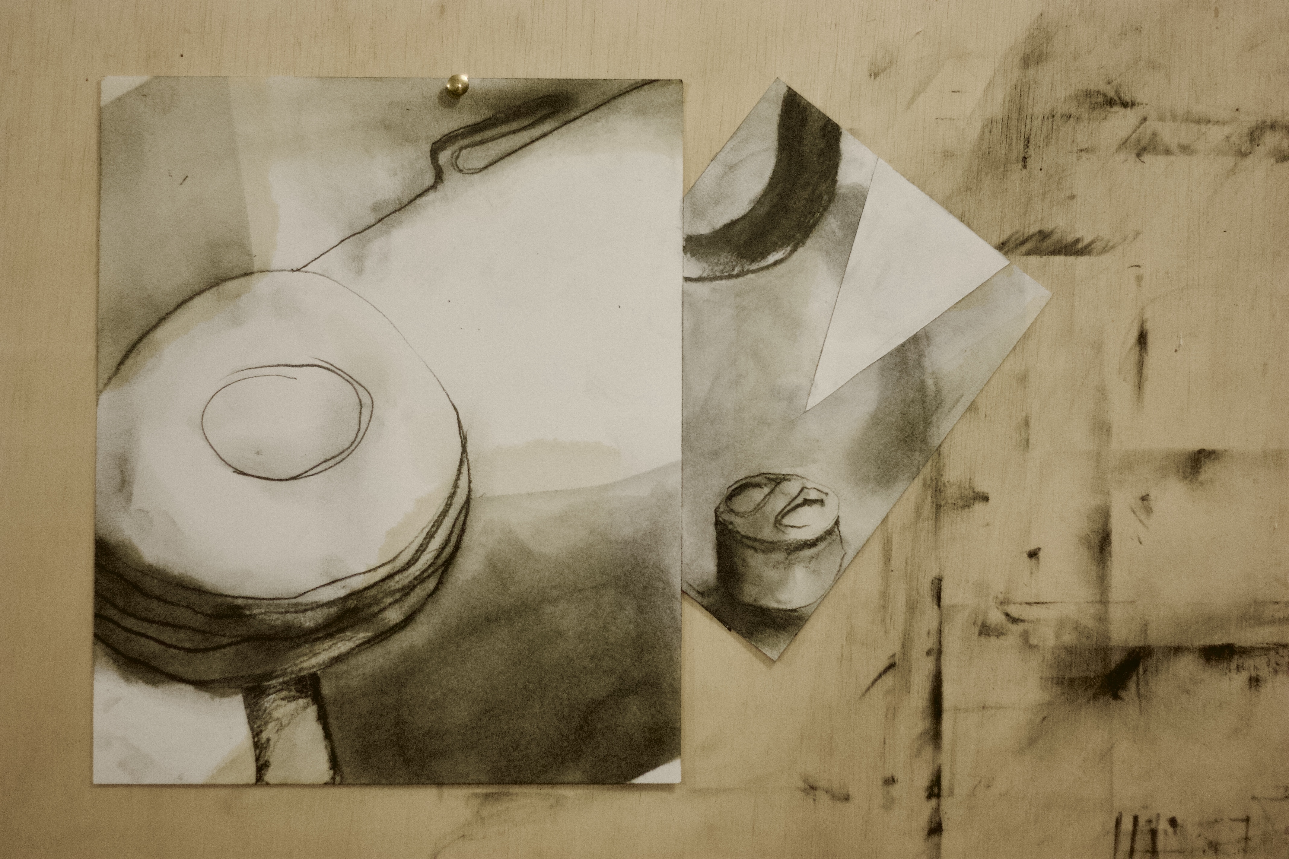 Composição com desenho circular e papel dobrado sobre madeira.